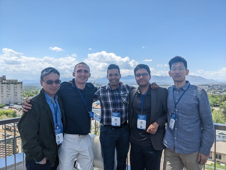 A photo of the 2023 CIROH group, pictured on a balcony overlooking a town with mountains in the back