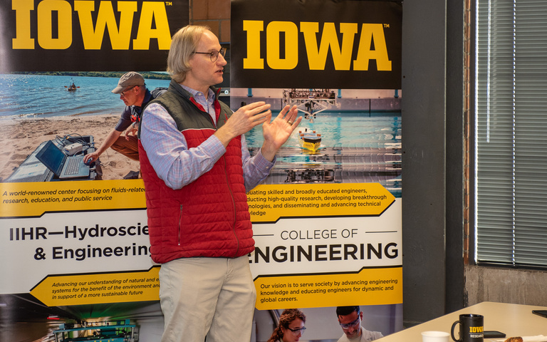 Steve Burian from CIROH stands at the front of the IIHR meeting room, addressing the crowd