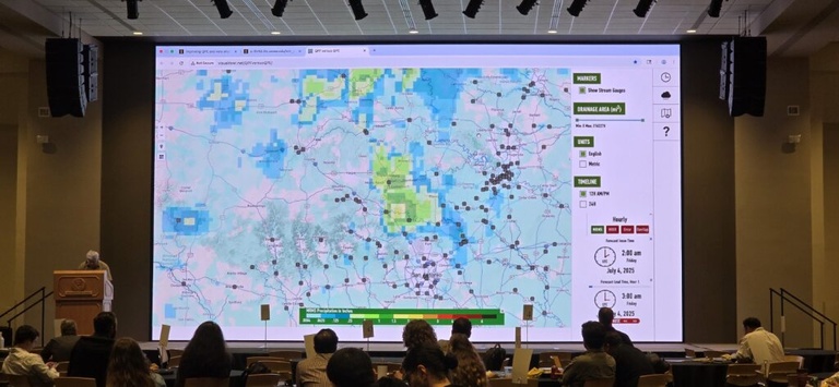 On a large projector, IFIS is displayed in front of a large crowd